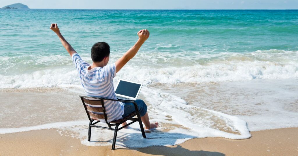 man working while enjoying at beach